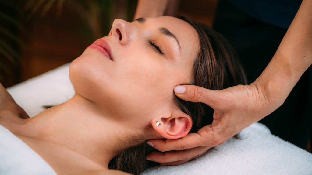 Cranial Osteopathy. Therapist Massaging Woman’s Head.